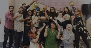 Group of professionals celebrating at an NLP training workshop